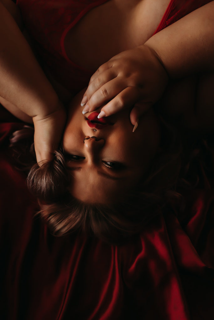 Woman laying on bed looking up into the camera for a boudoir shoot with sommer fine art studio in West Richland, WA